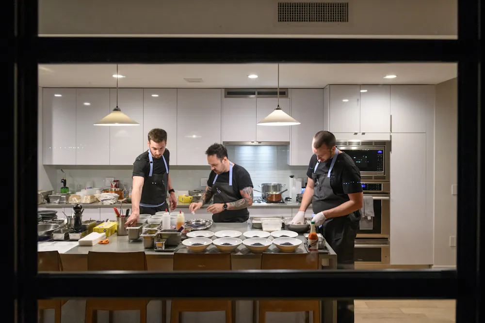 a man and woman preparing food in a kitchen