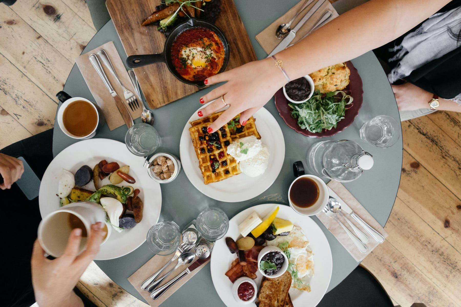 a group of people sitting at a table with a plate of food