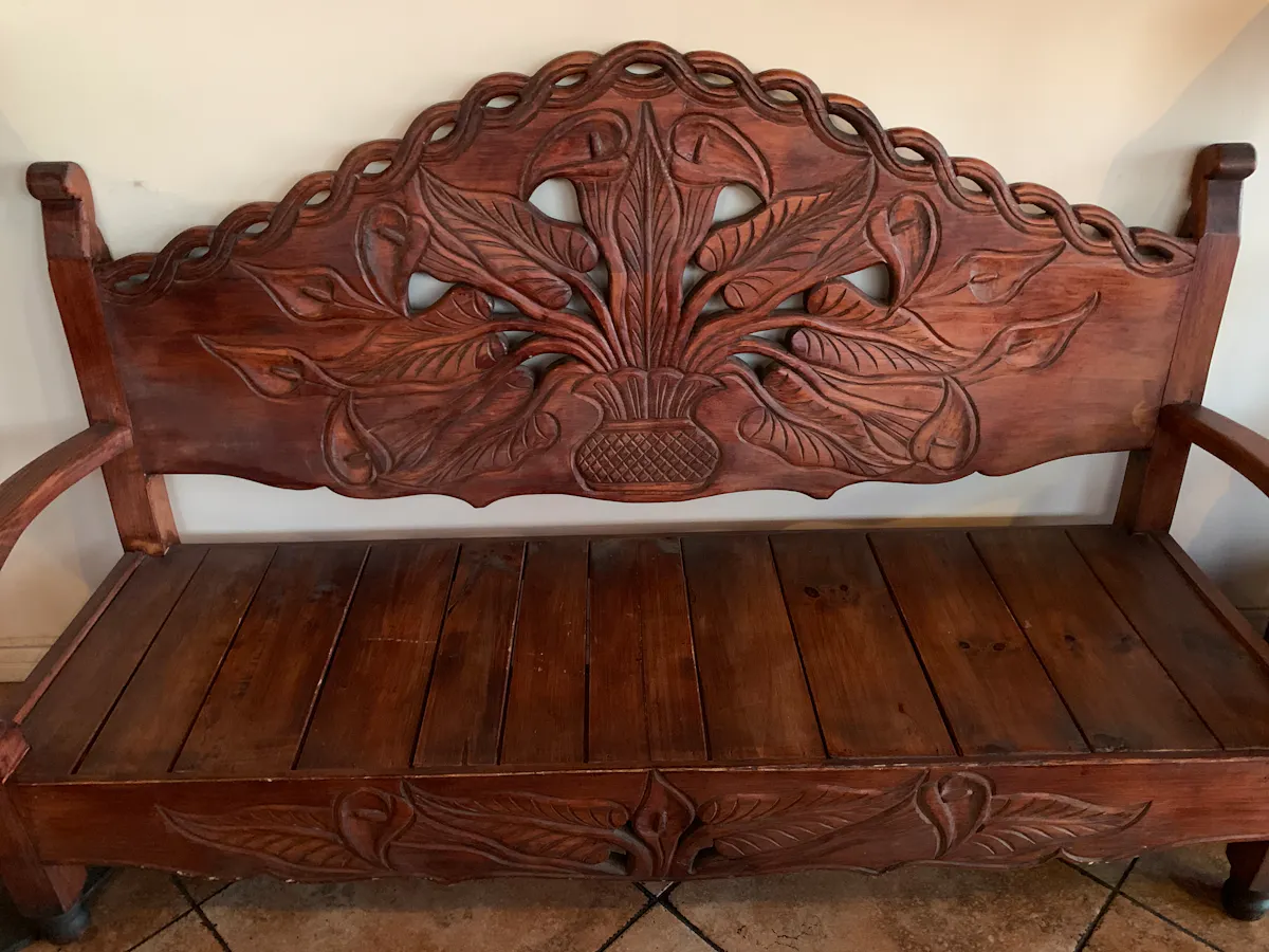 a brown wooden bench sitting in a chair