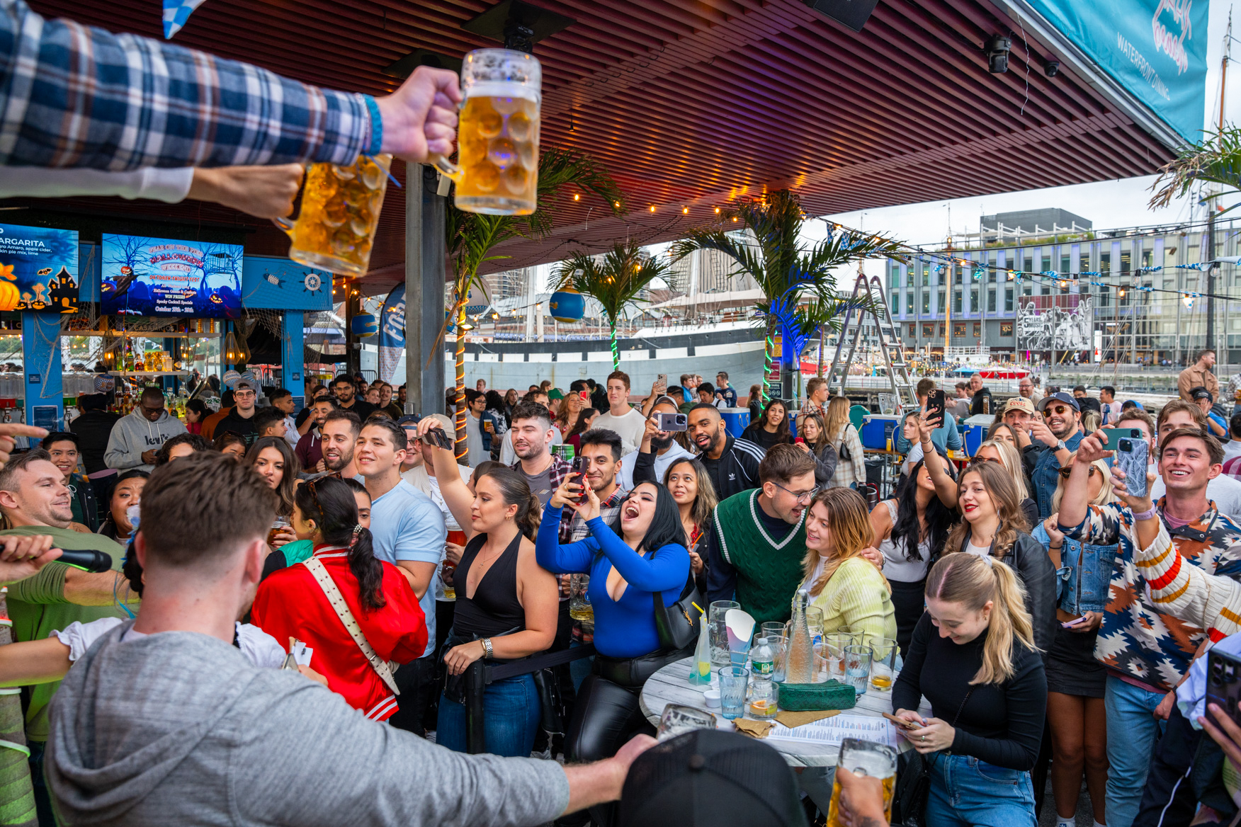Guests celebrating Oktoberfest at Watermark with steins of beer