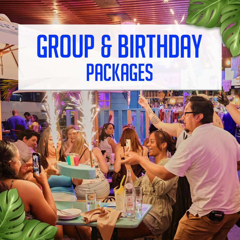 Large group dining under string lights with skyline views at Watermark
