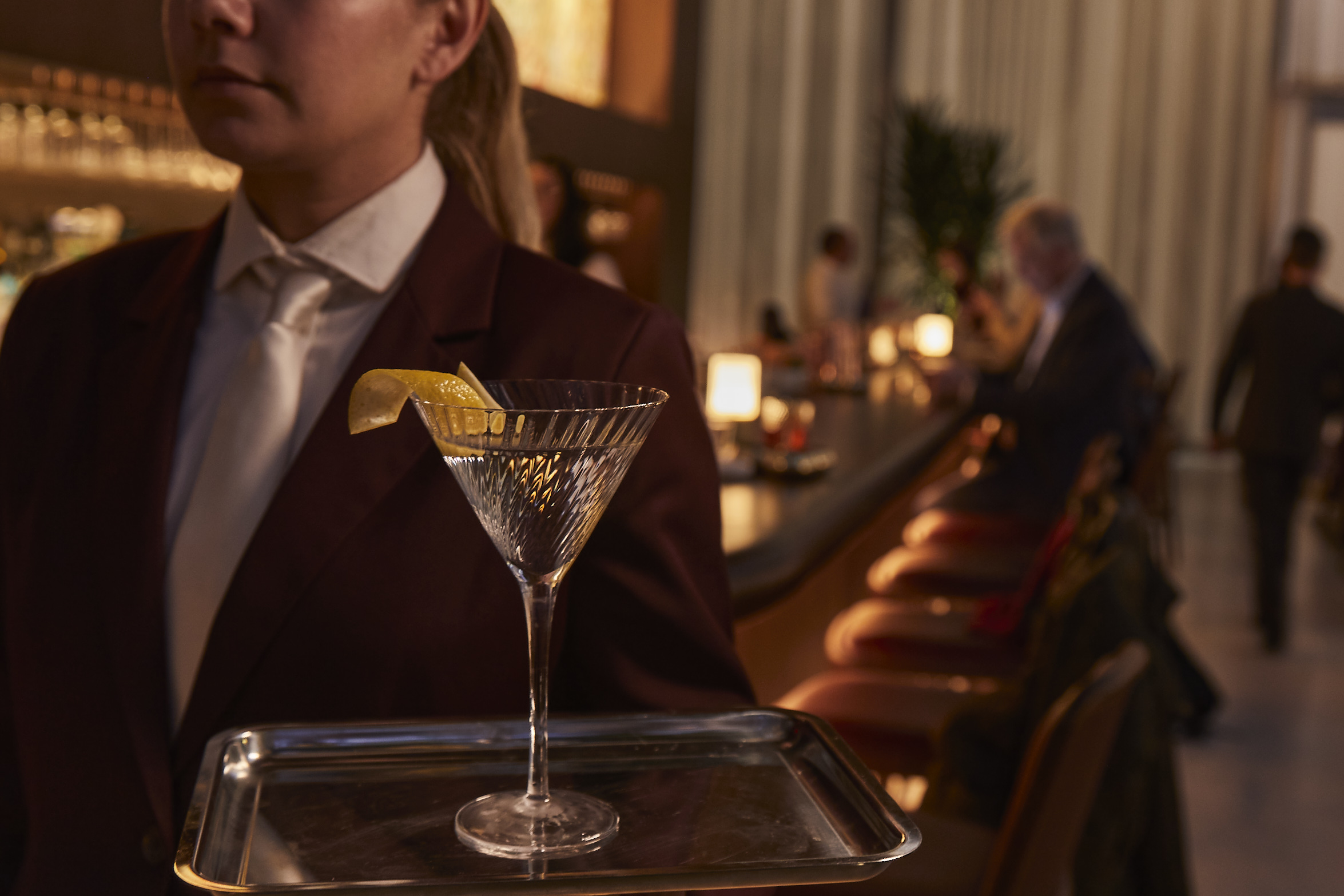 a person wearing a suit and tie holding a glass of wine