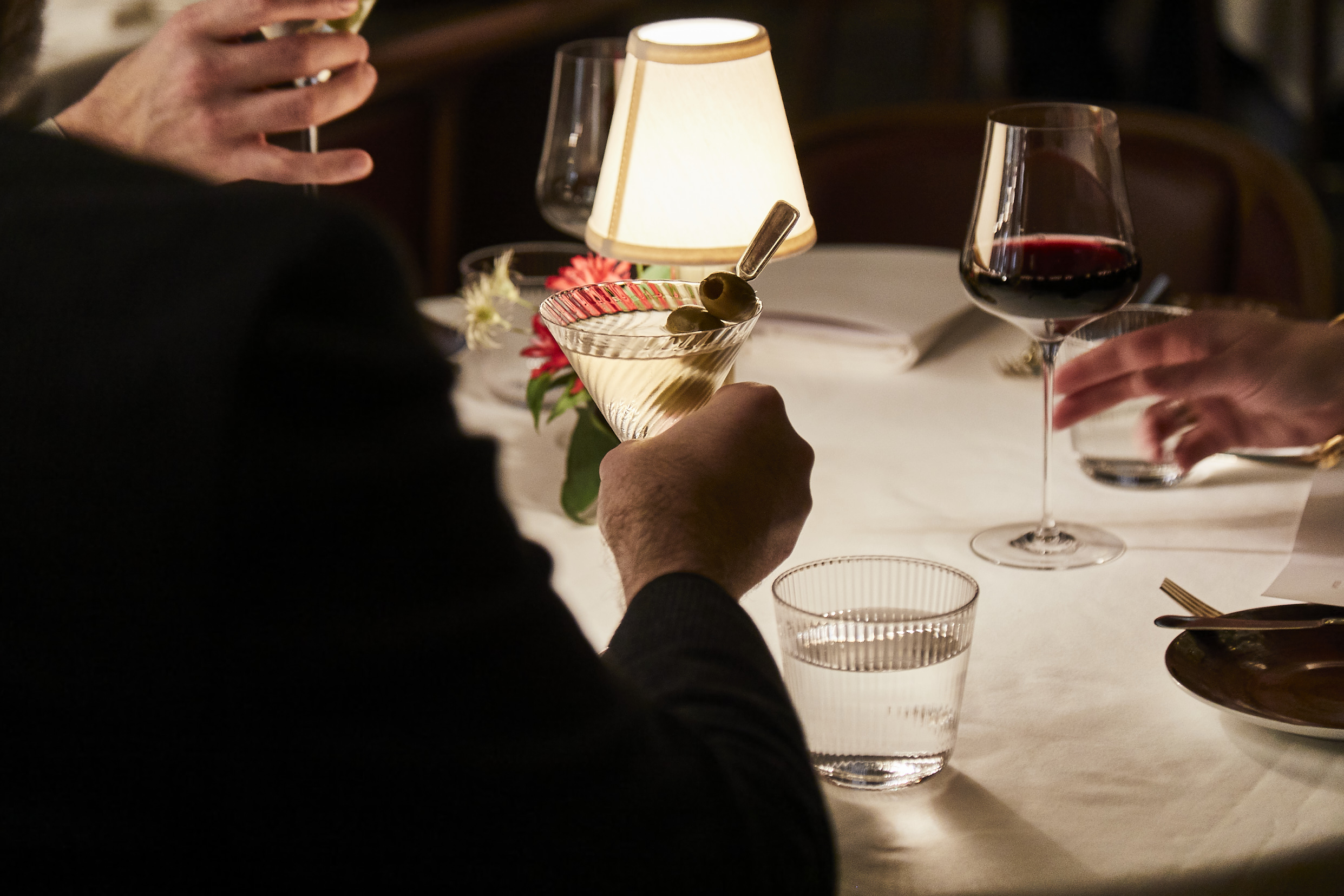 a person sitting at a table with wine glasses