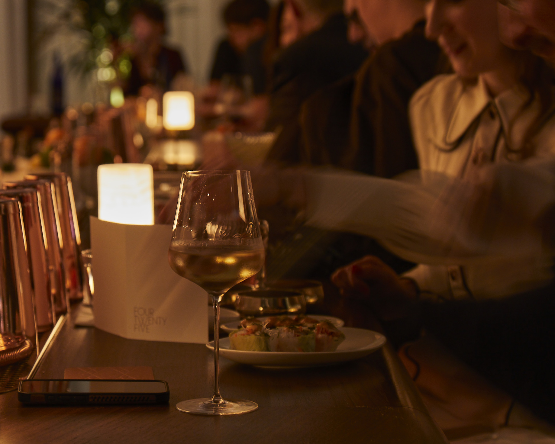 a person sitting at a table with wine glasses