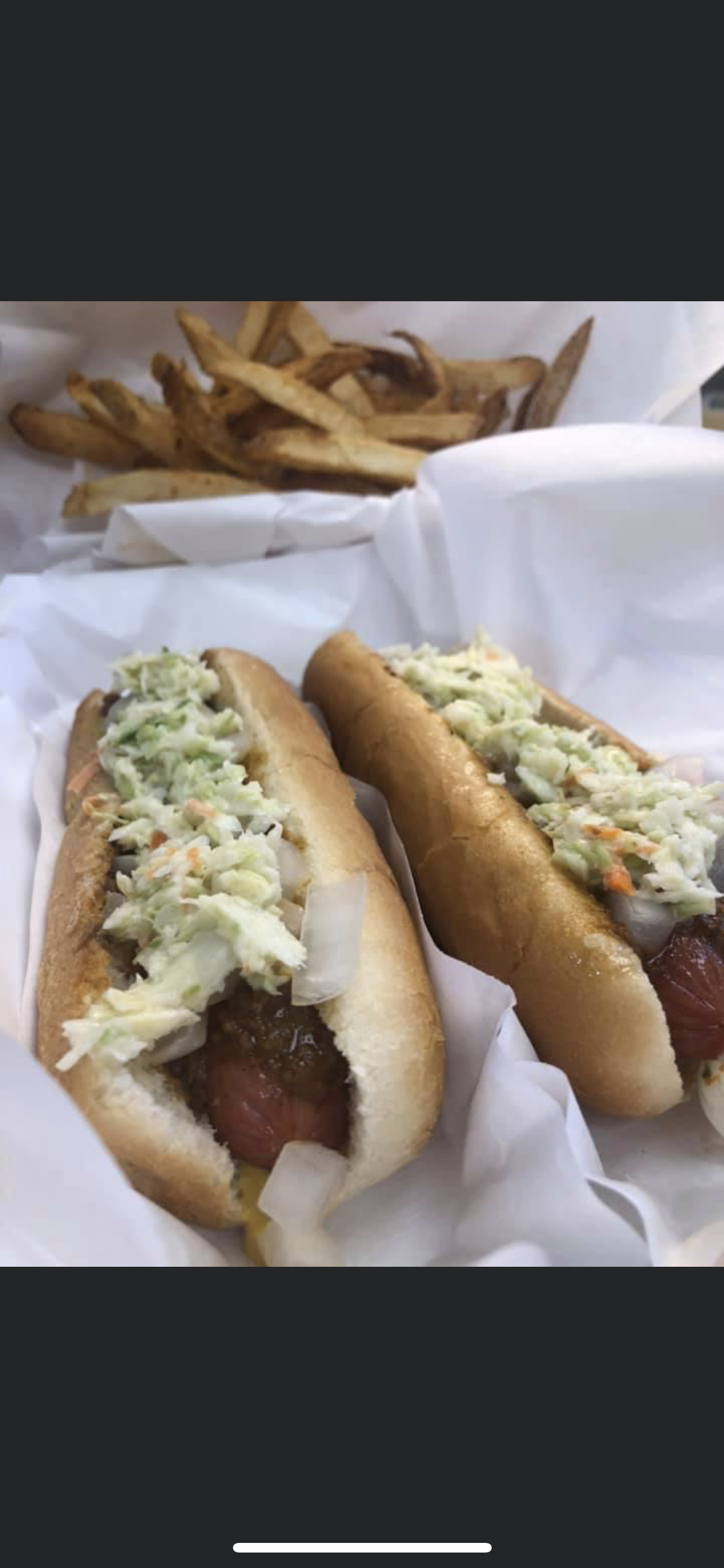 a hot dog on a bun covered in toppings