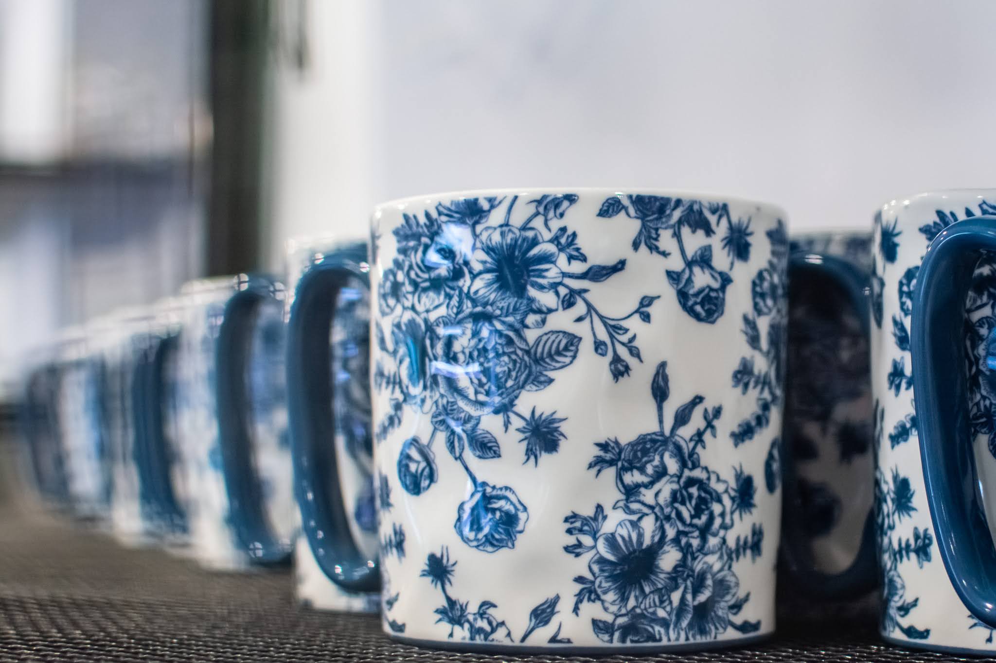 a glass with a blue vase on a table