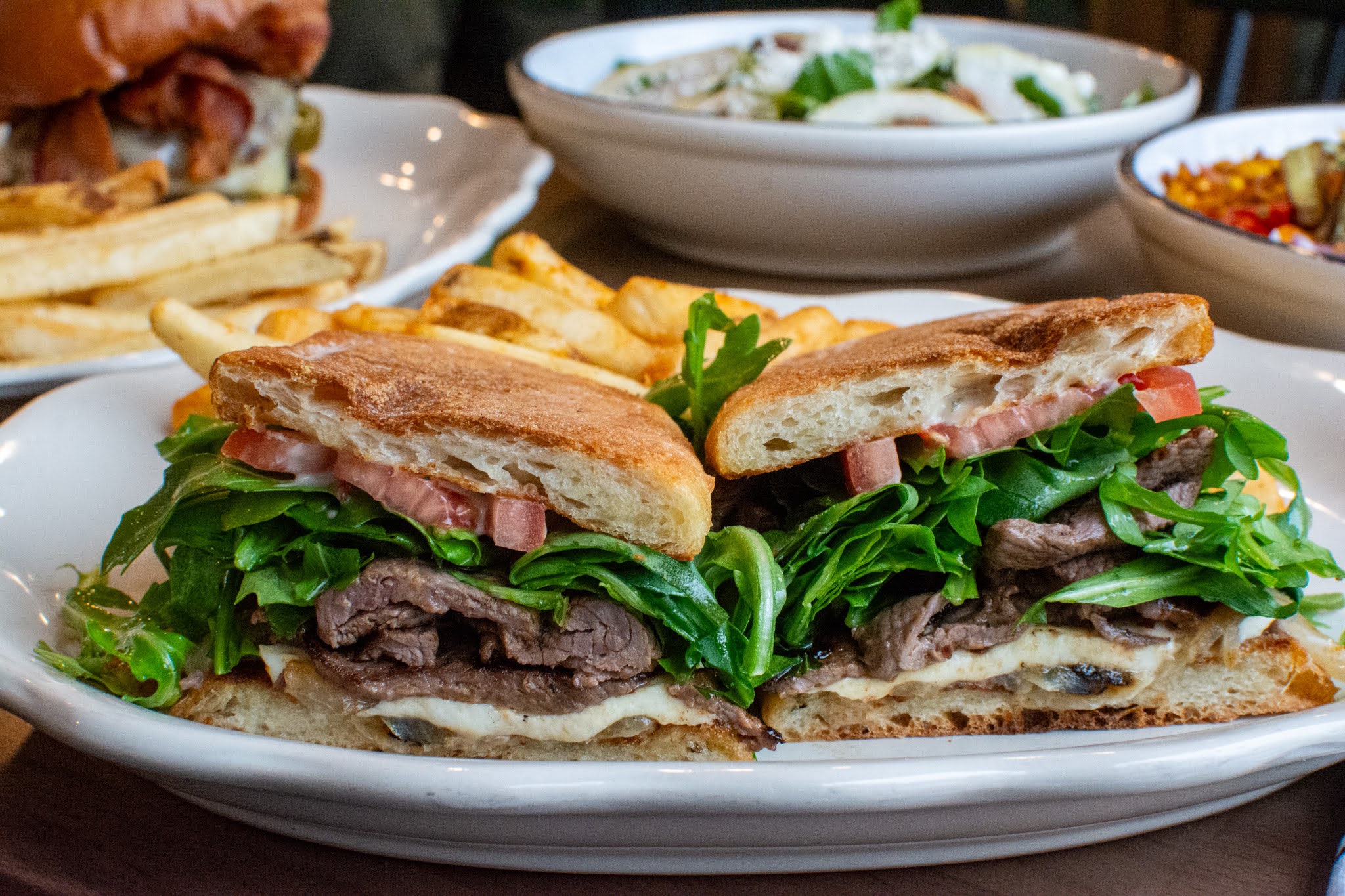 a close up of a plate of food with a sandwich and a salad