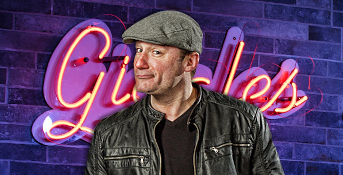 a man wearing a hat in front of a brick wall