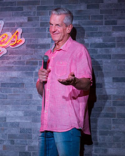 Lenny Clarke standing in front of a brick building