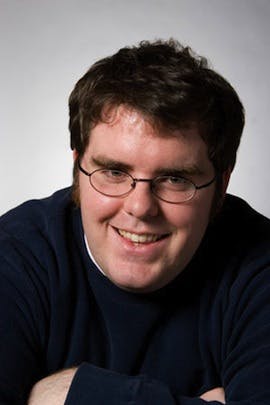 a man in glasses looking at the camera