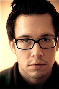a man wearing glasses and looking at the camera