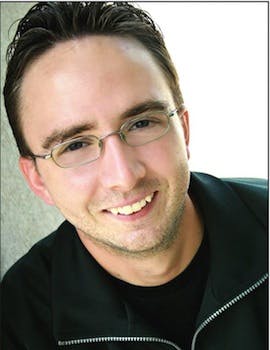 a man wearing glasses and smiling at the camera