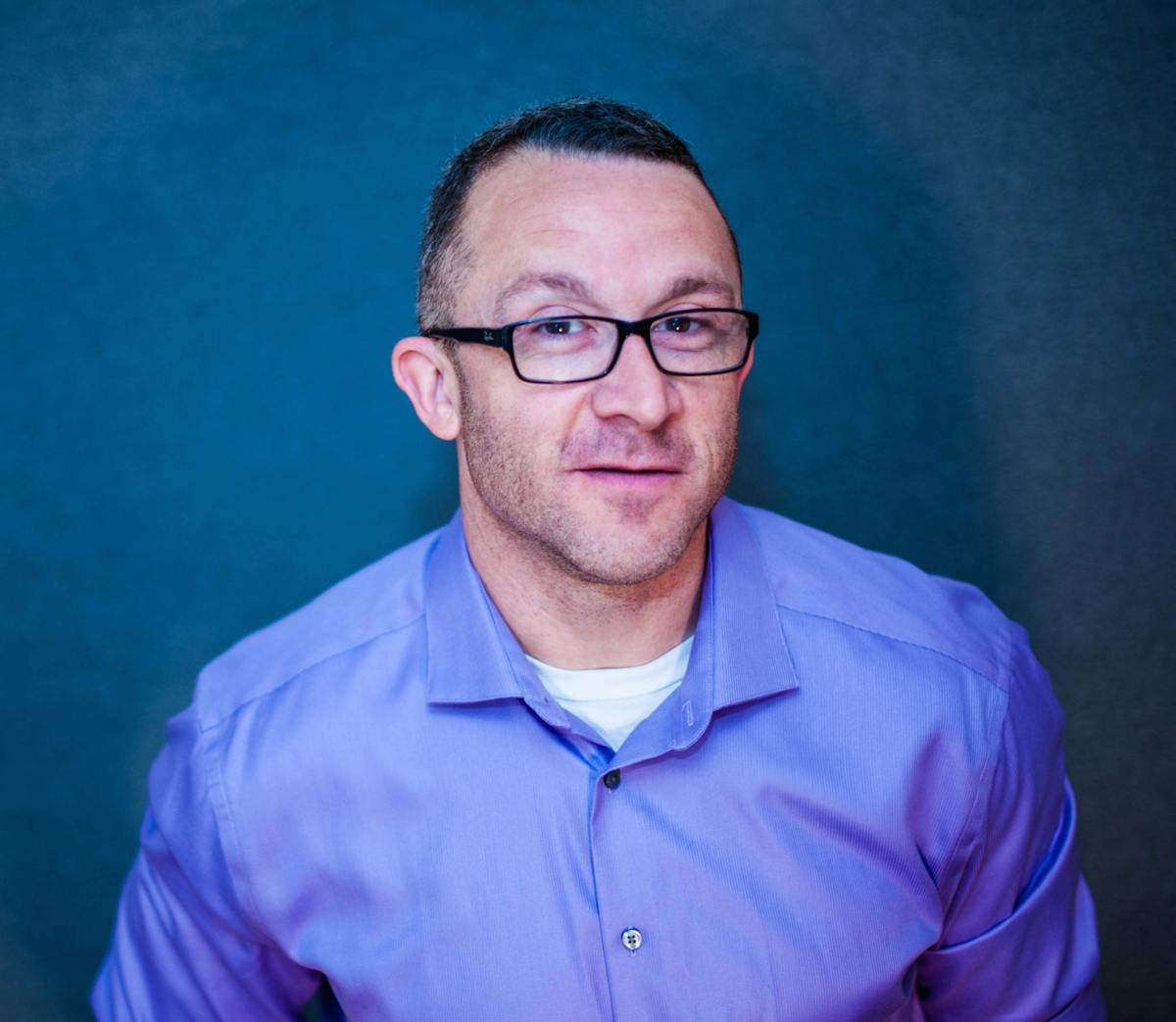 a man wearing glasses and a blue shirt
