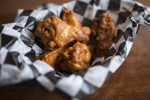 a basket filled with hot spicy buffalo drumsticks