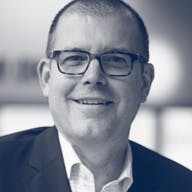 a man wearing glasses and smiling at the camera