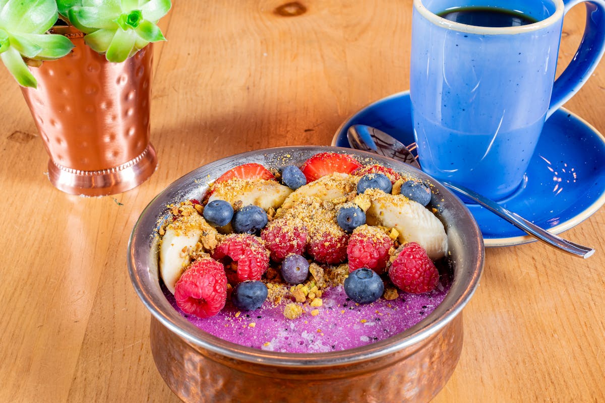 a cup of coffee sitting on top of a wooden table