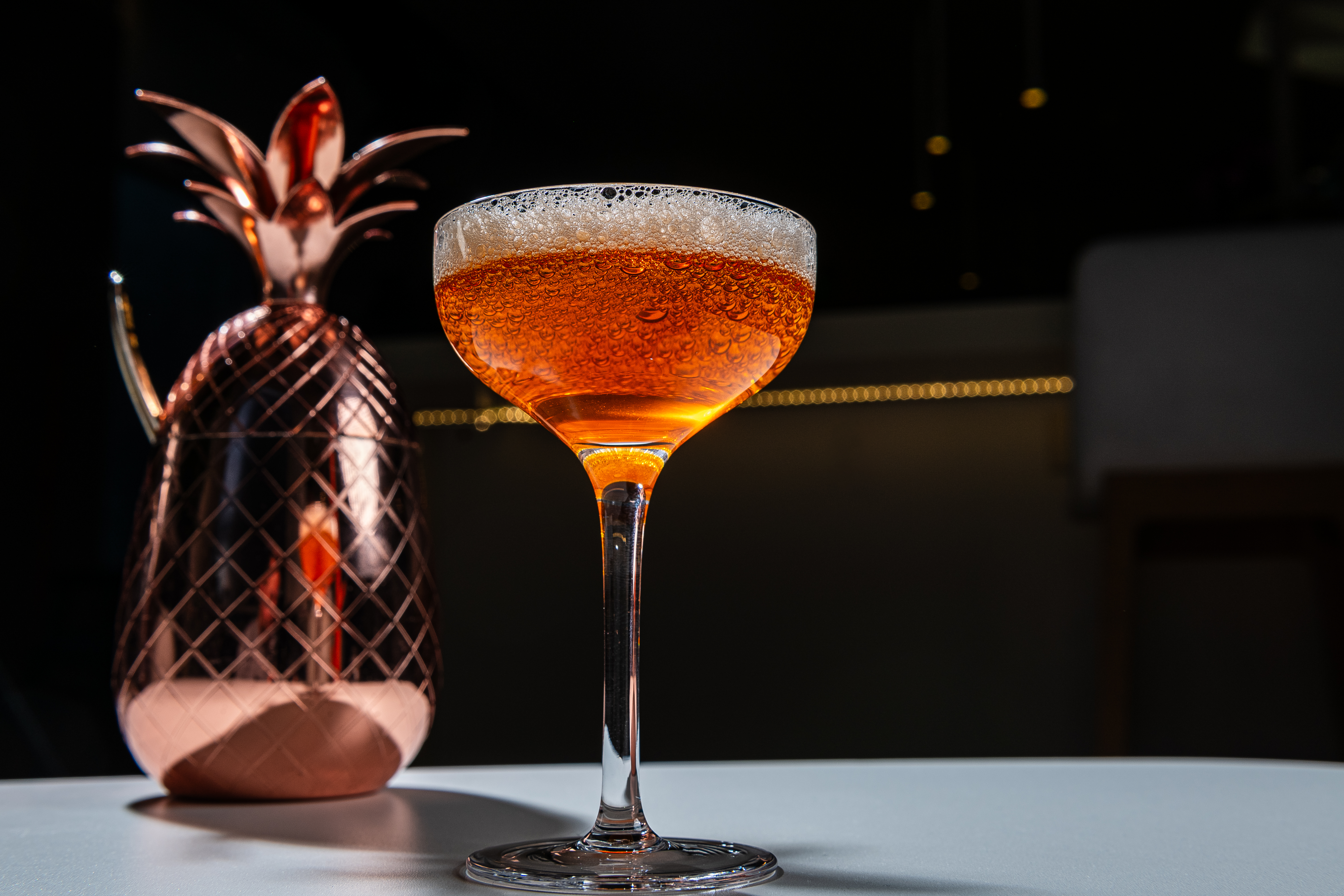 cocktail in front of a copper pineapple