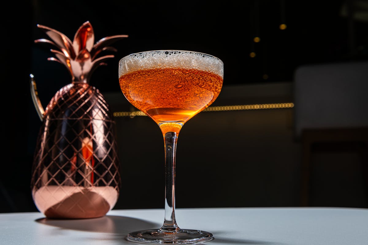 cocktail in front of a copper pineapple