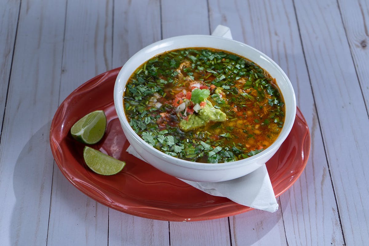 a bowl of food sitting on top of a wooden table