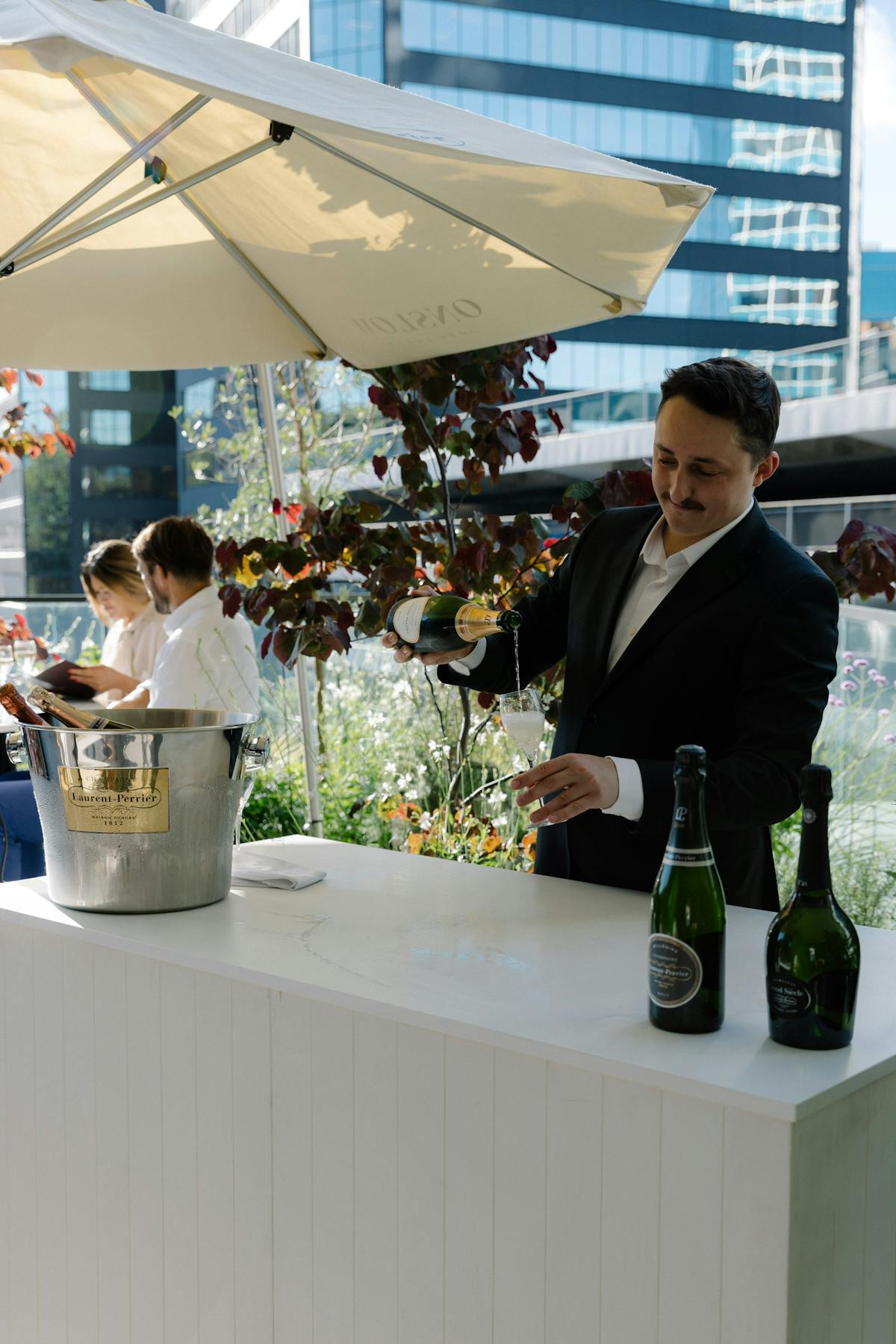 a group of people sitting at a table with an umbrella