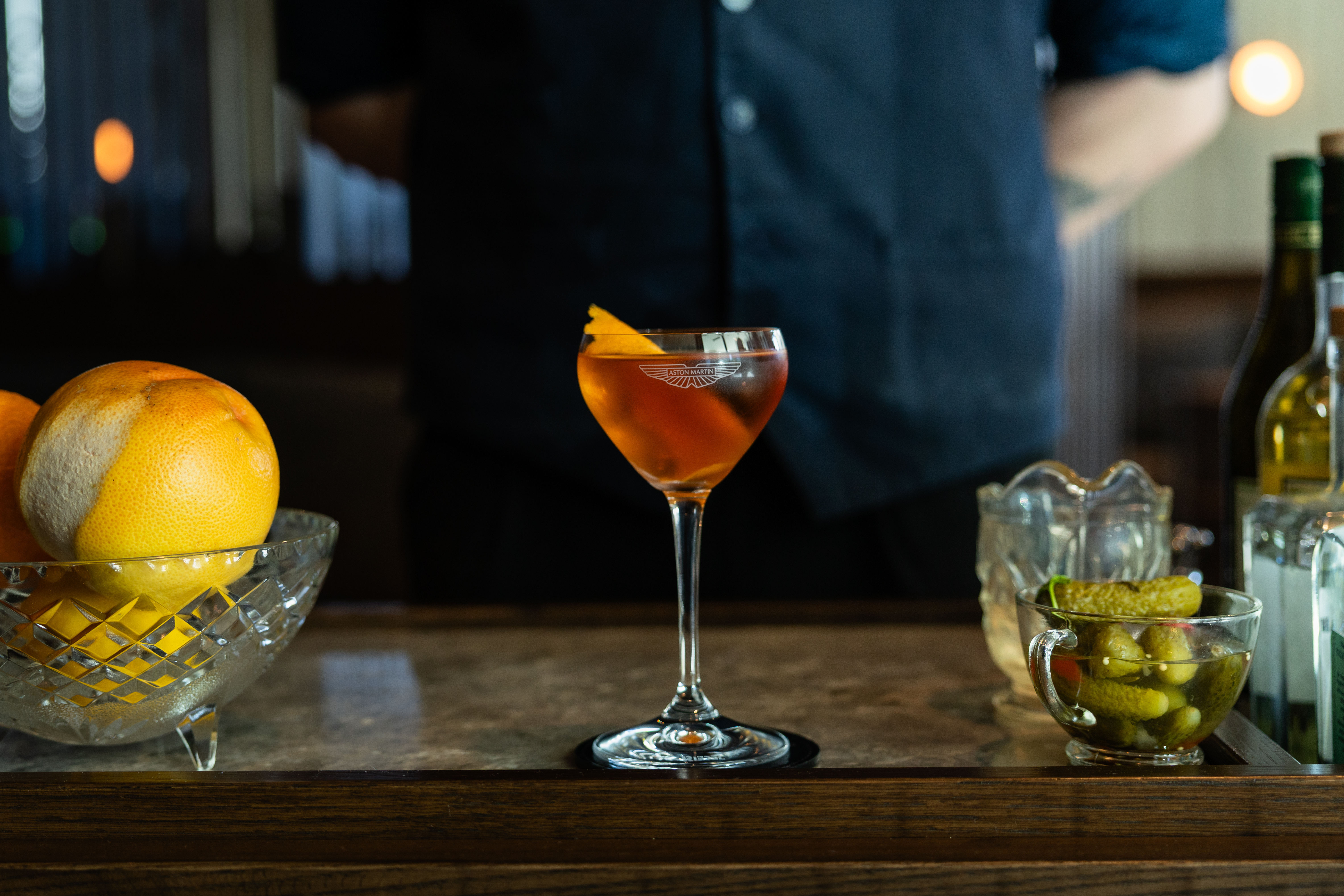 a glass of liquid next to a bowl of fruit