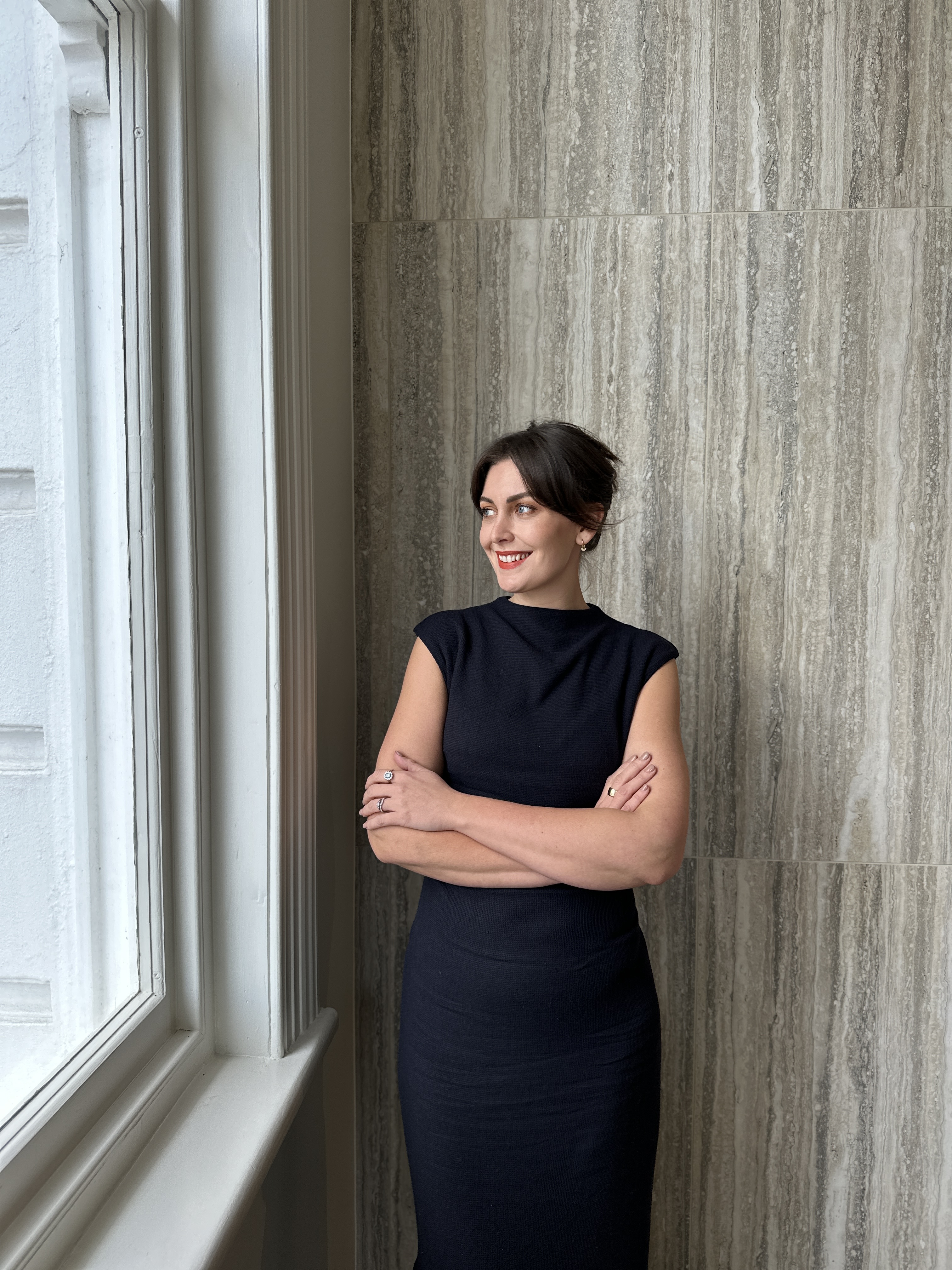 a woman standing in front of a curtain