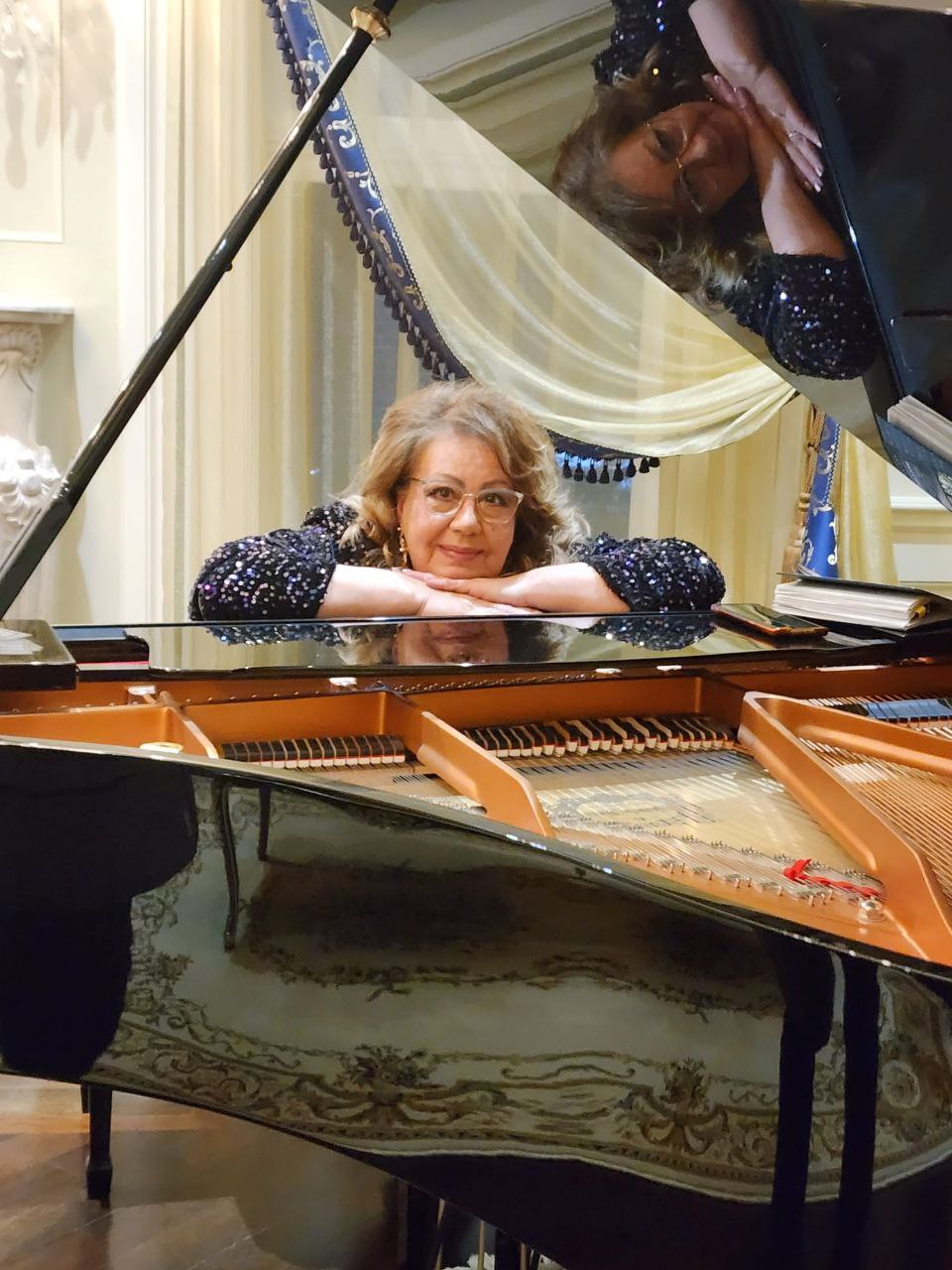a woman sitting behind a piano