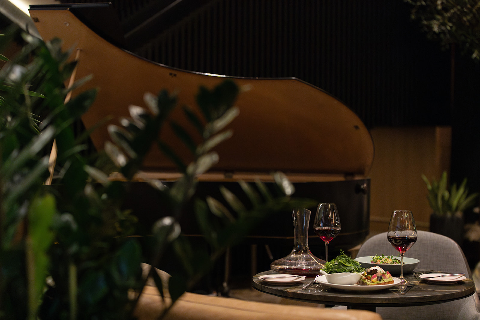 A cozy restaurant featuring a grand piano and elegant chairs, creating an inviting atmosphere for dining and music