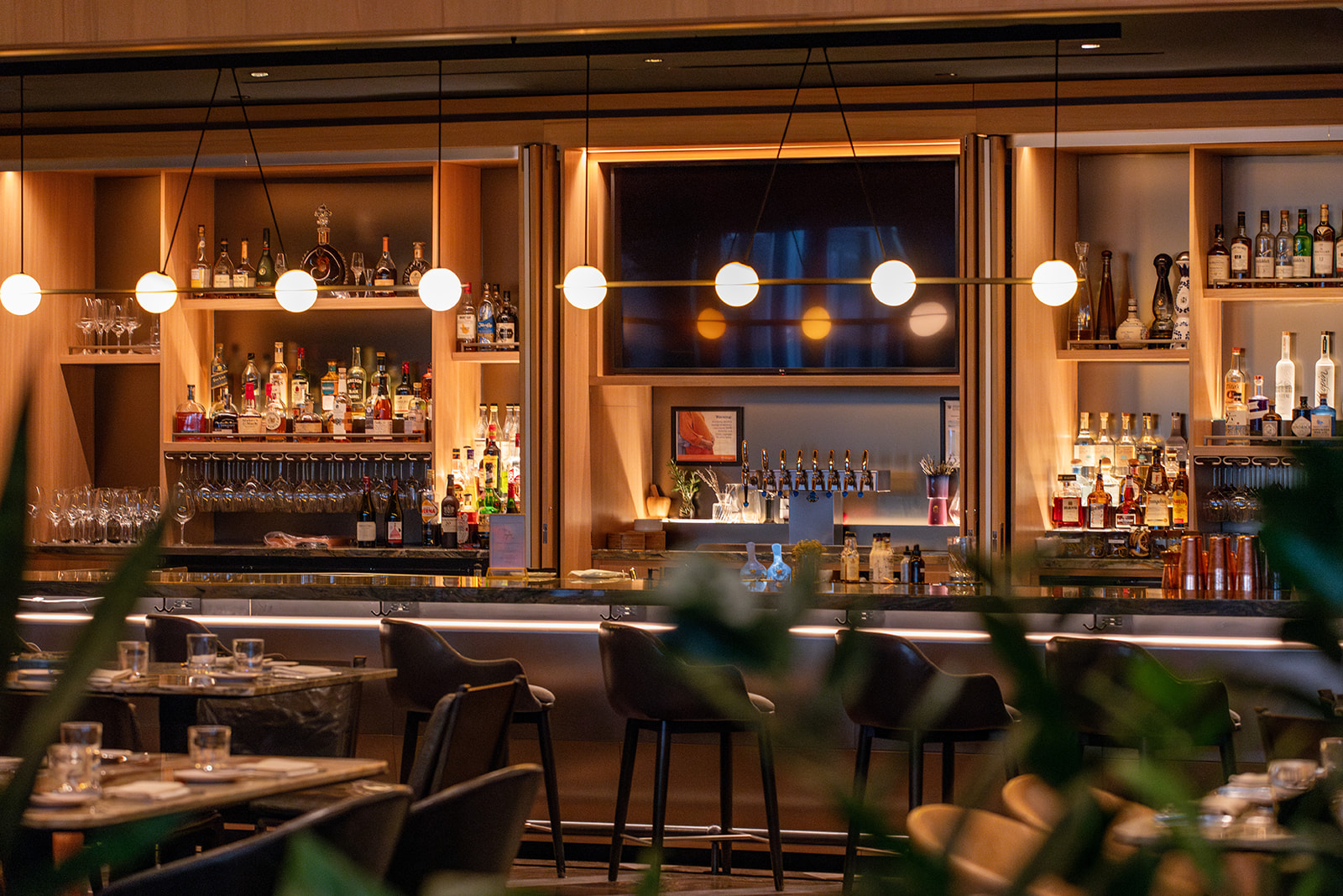 A well-stocked hotel bar featuring an array of spirits, elegant glassware, and a warm, inviting atmosphere