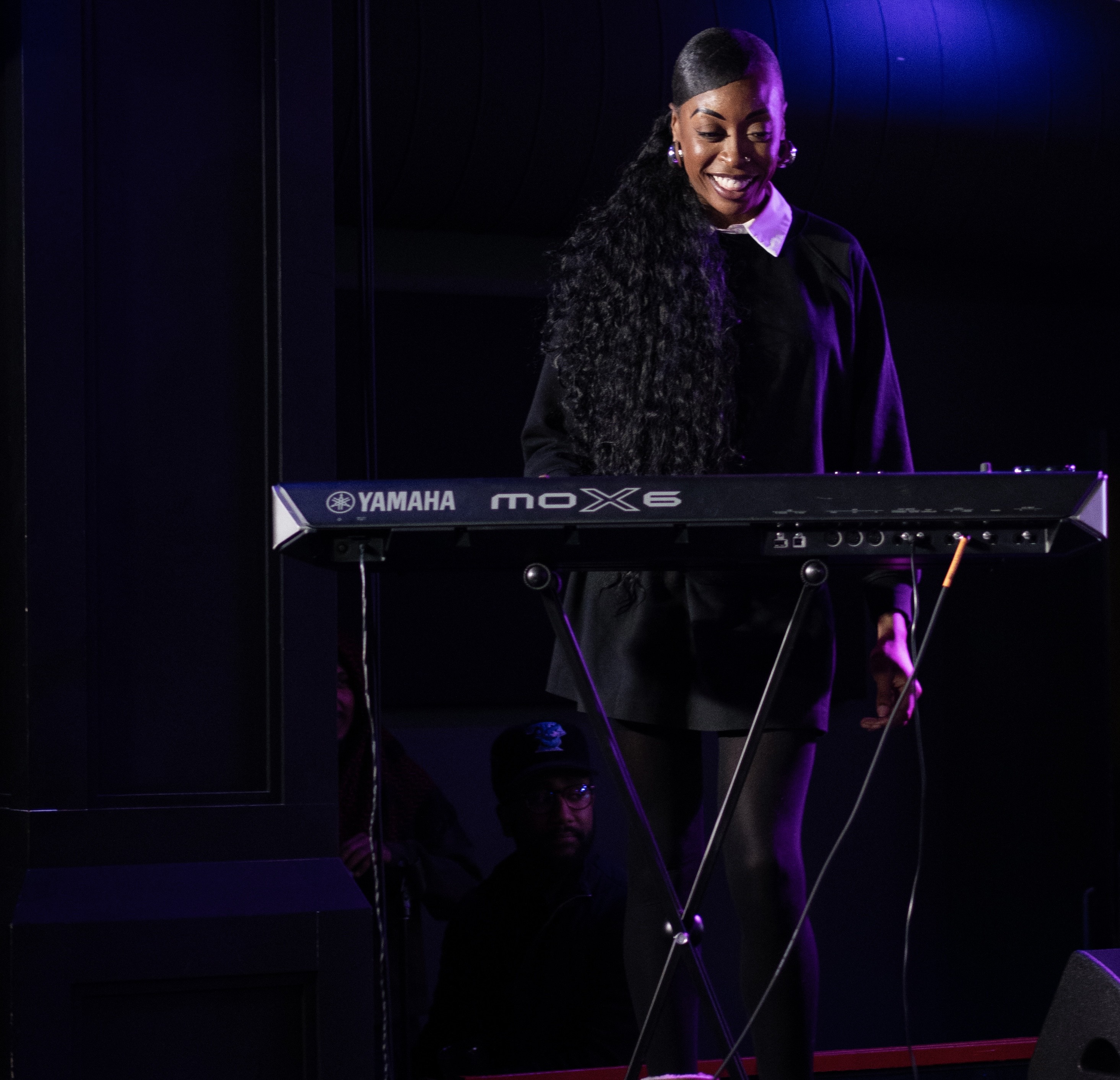a woman standing on a stage playing a keyboard