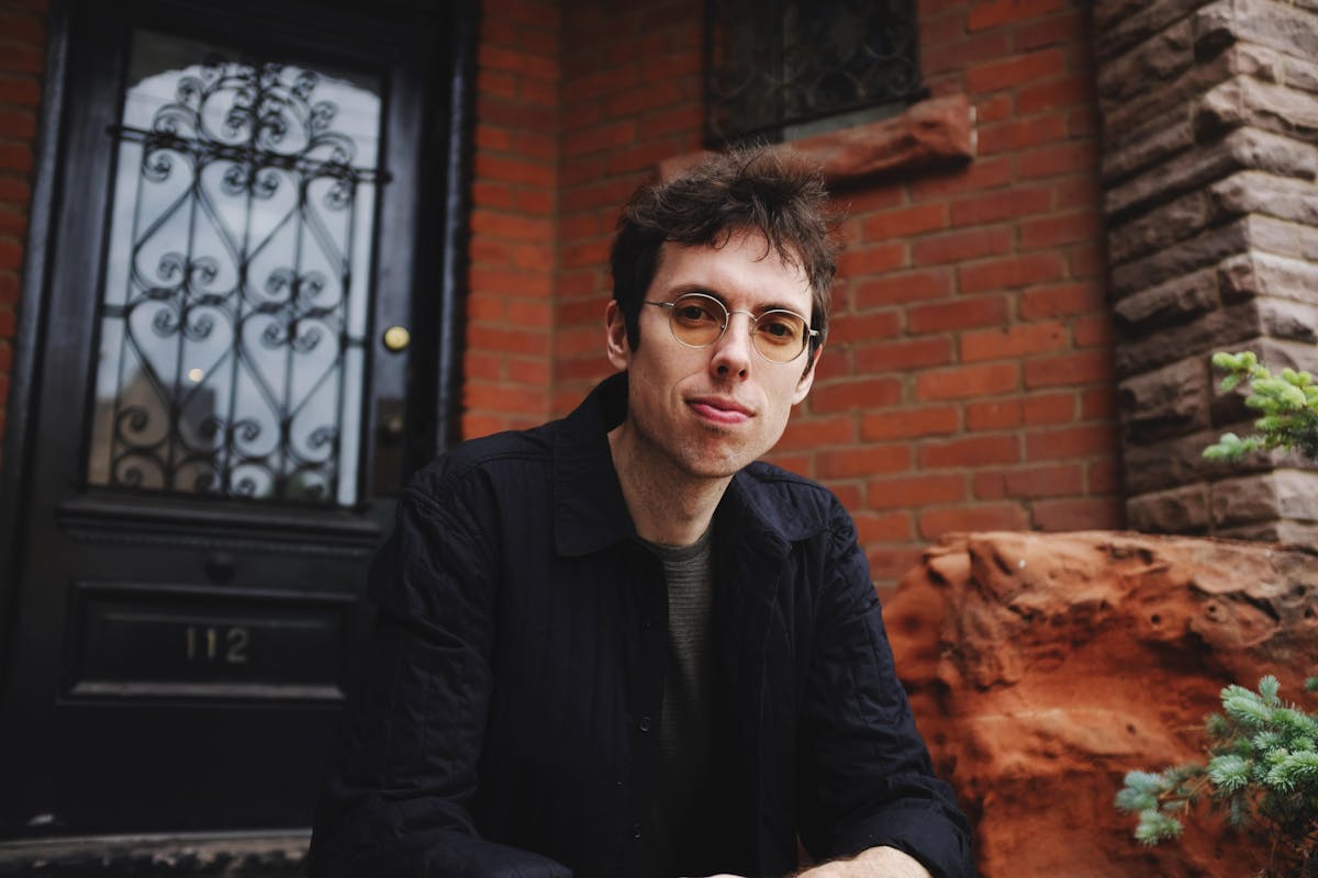 a man standing in front of a brick building