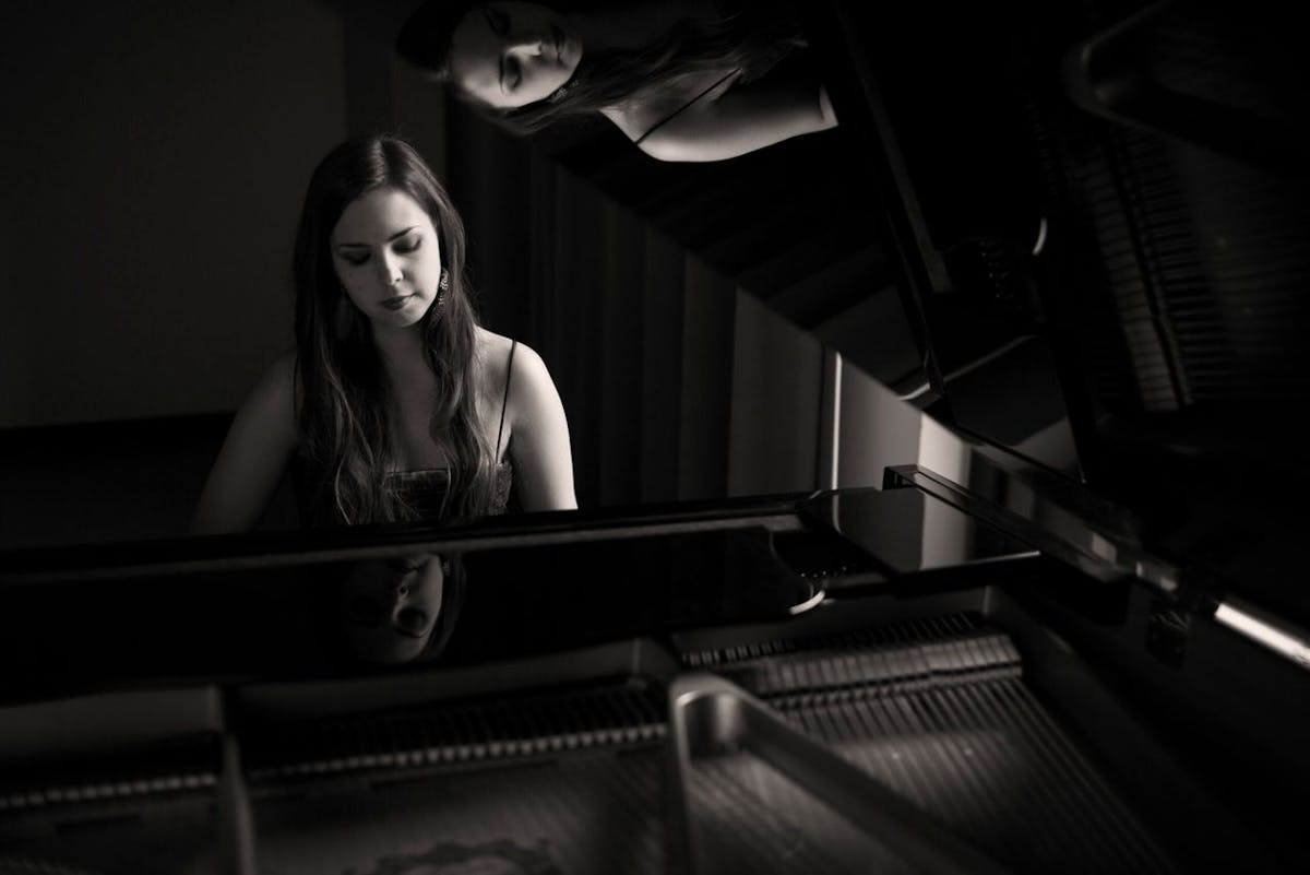a woman standing in front of a piano