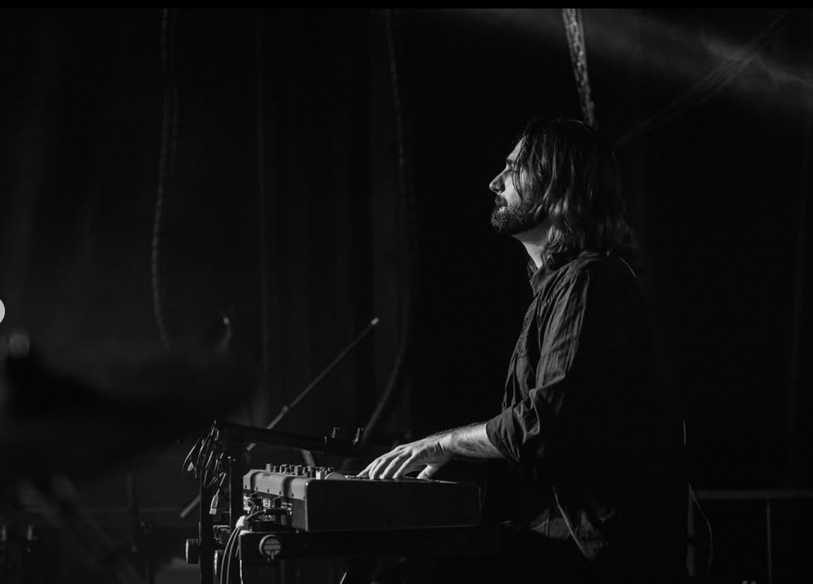 a person sitting on a stage in front of a piano