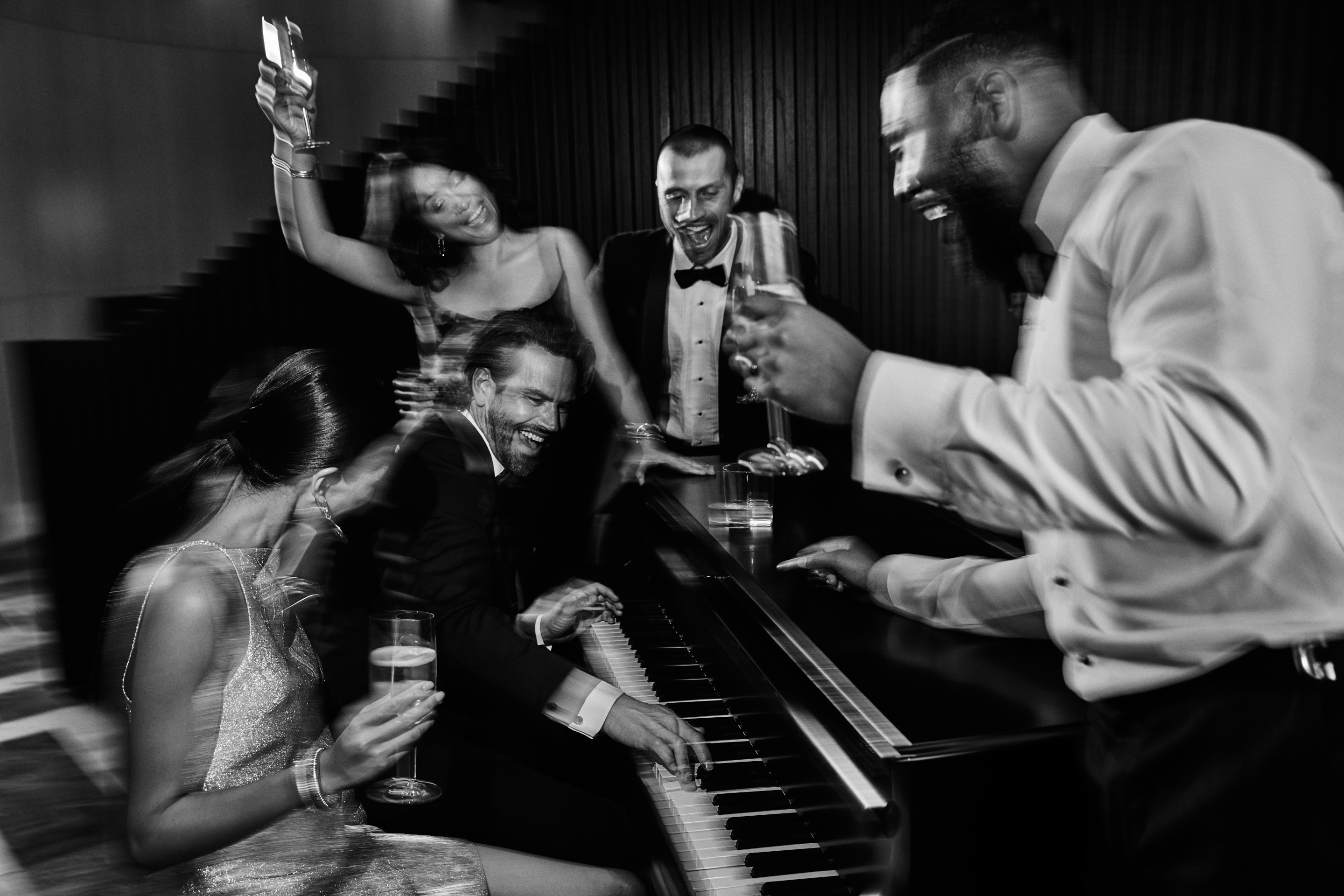 A group of elegantly dressed individuals enjoying themselves at a lively party atmosphere