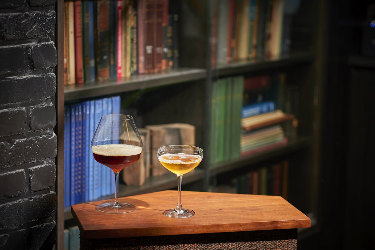 a glass of wine sitting on top of a wooden table