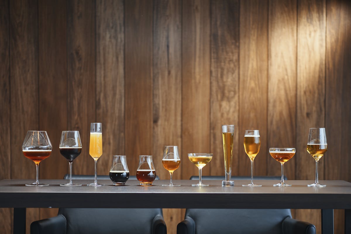 a row of wine glasses sitting on top of a wooden table