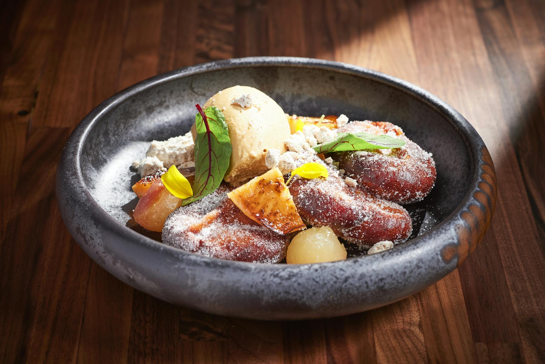 a bowl of food sitting on top of a wooden table