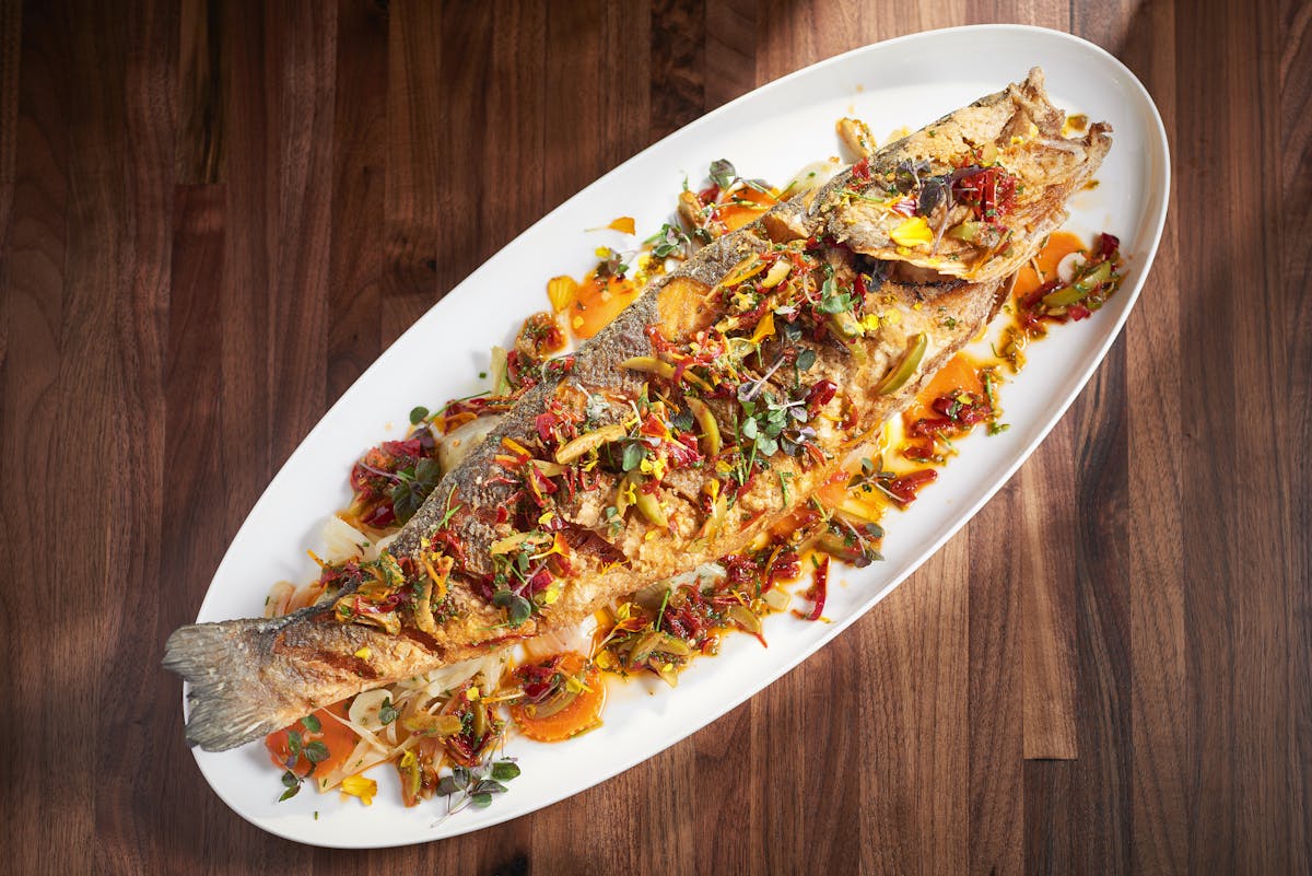 a fish sitting on top of a wooden table