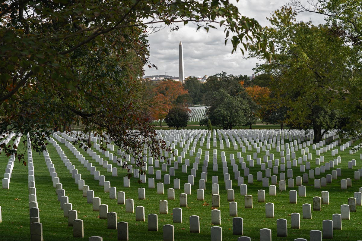 a group of people in a field with Arlington National Cemetery in the background