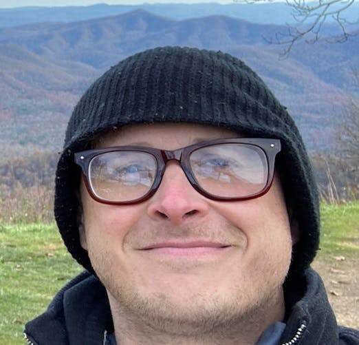a close up of a man wearing a hat and glasses