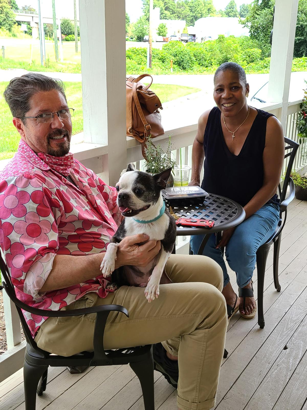 a man and a woman sitting on a bench with a dog