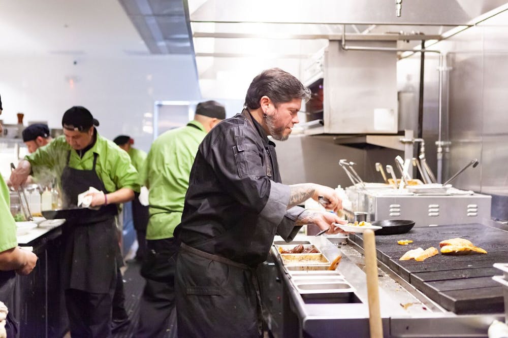 a man standing in a kitchen preparing food