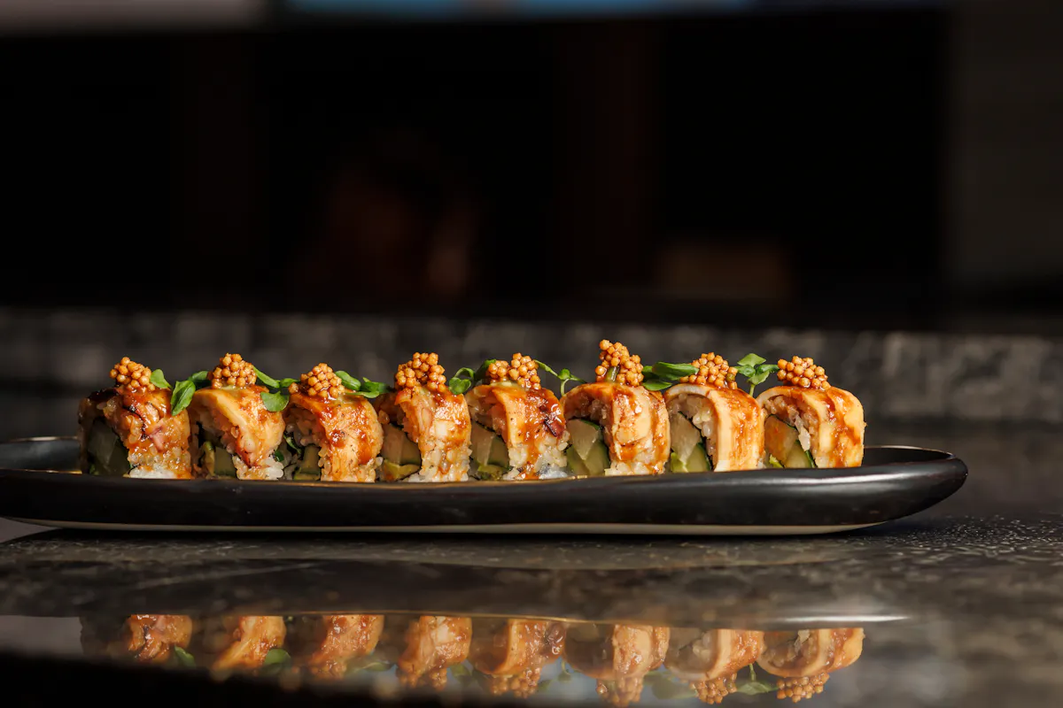 a plate of sushi on a black surface