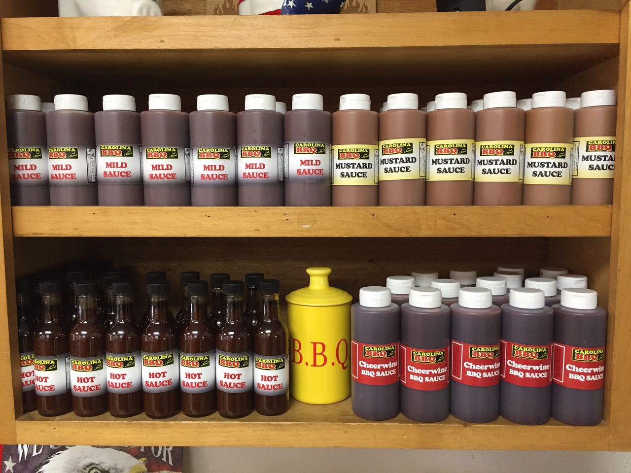 a shelf with bottles of sauces