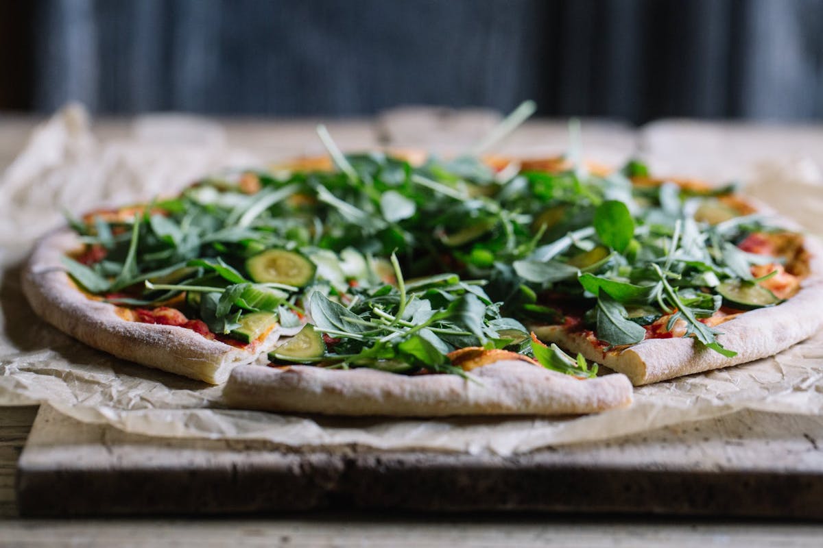 a pizza sitting on top of a wooden cutting board