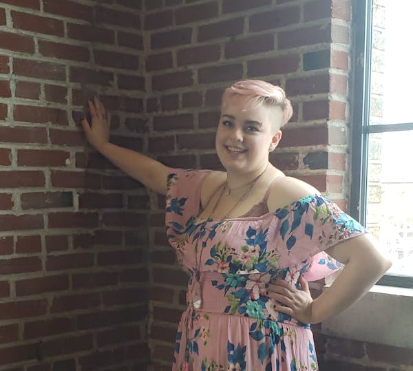 a woman standing in front of a brick building