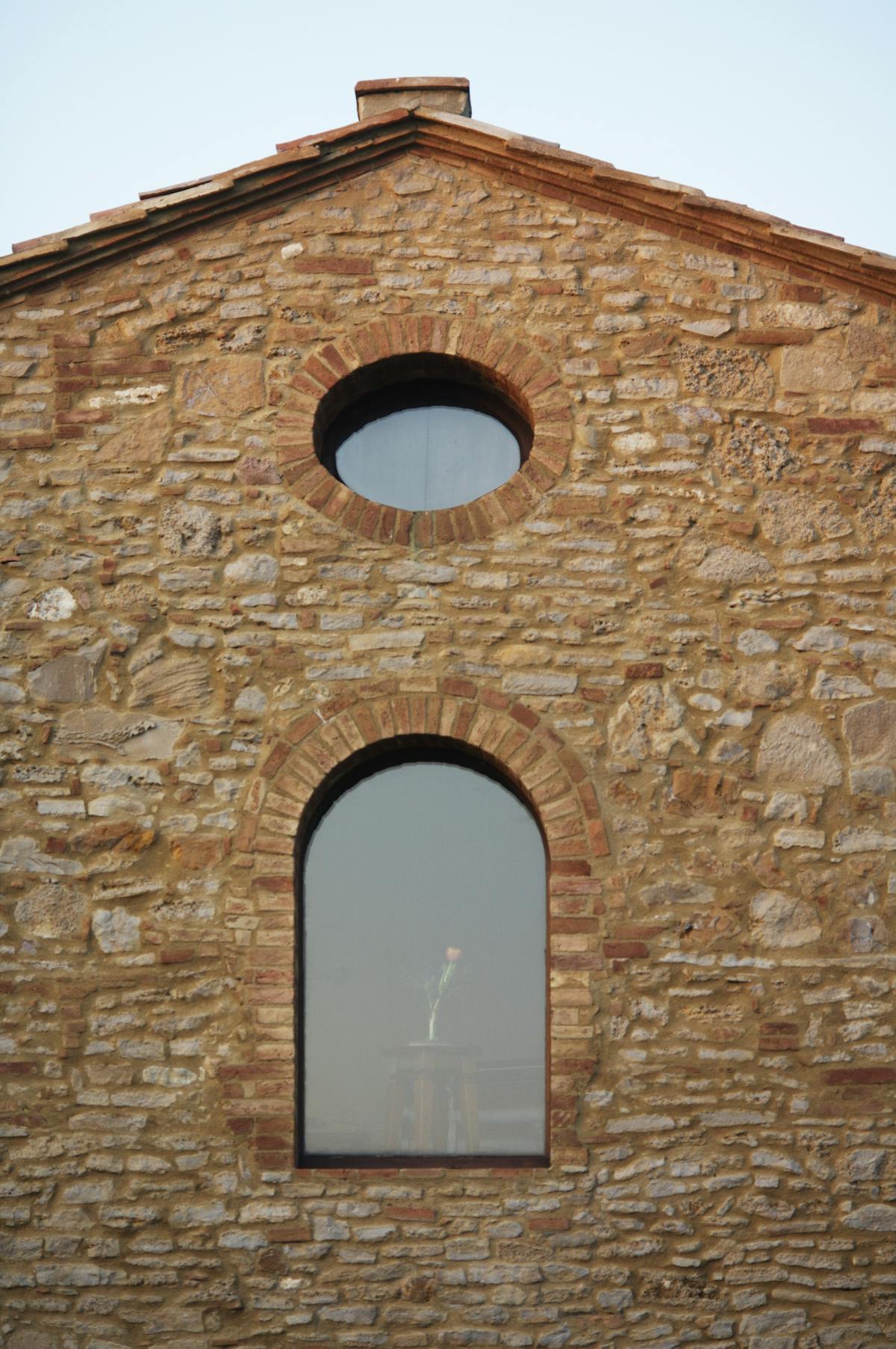a large stone building with a clock on the side of a brick wall