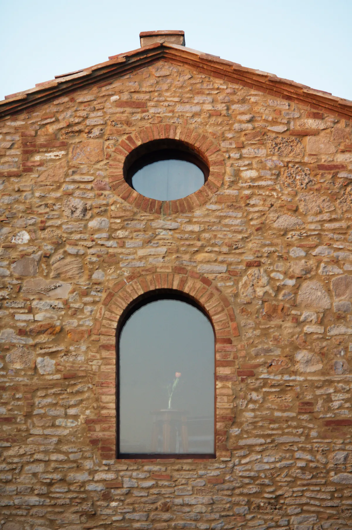 a large stone building with a clock on the side of a brick wall