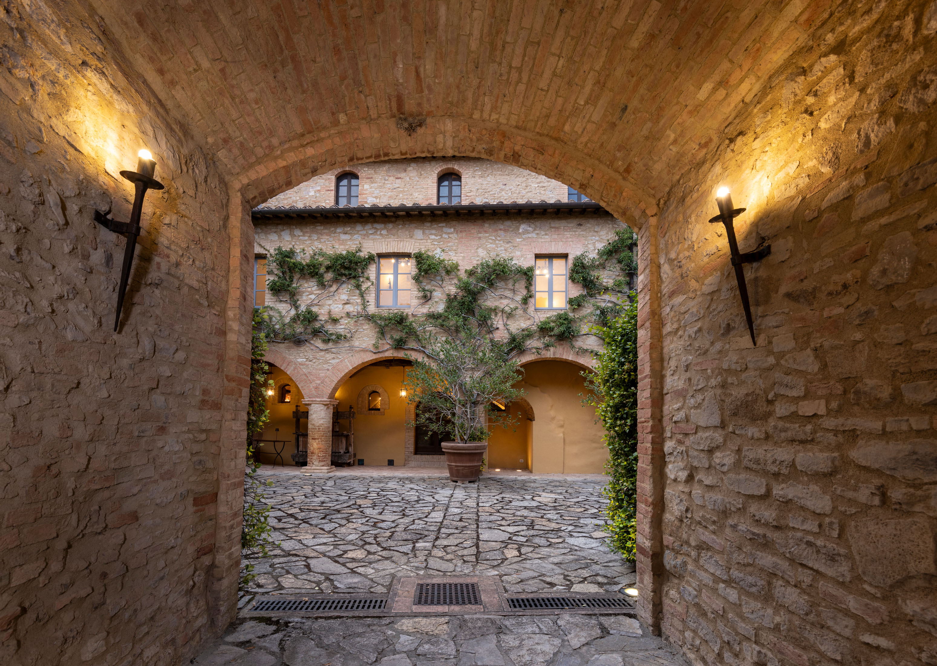 a stone building that has a clock at the top of a brick wall