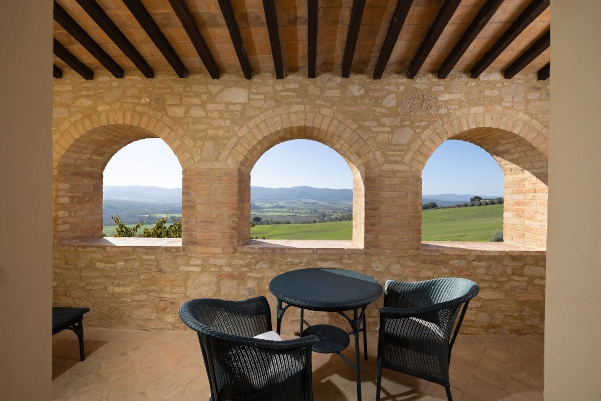 a stone building that has a clock at the top of a brick wall